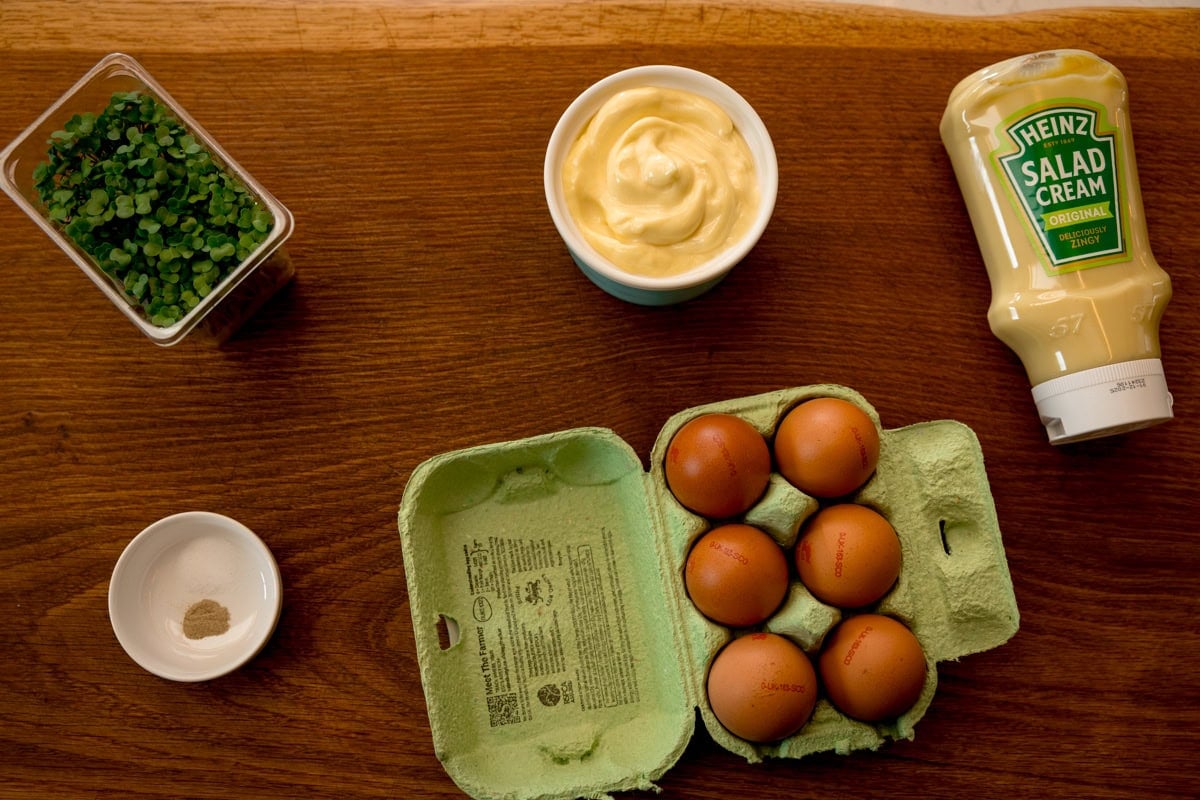 Ingredients for egg mayonnaise on a wooden board.