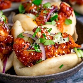 Close up image of mini Korean chicken bao buns on a dark background