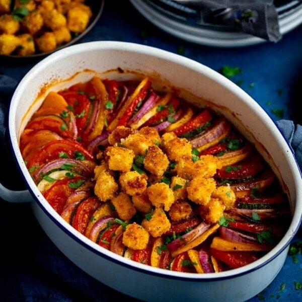 Close up of a dish of ratatouille on a blue background