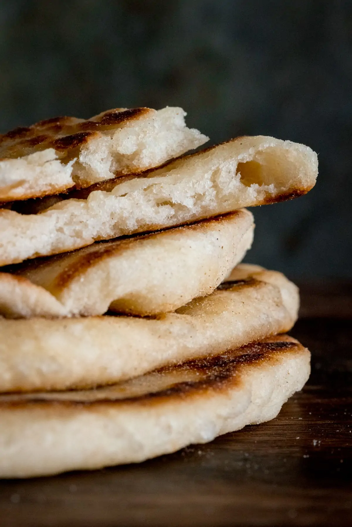 Close up a stack of flatbreads against a dark surface